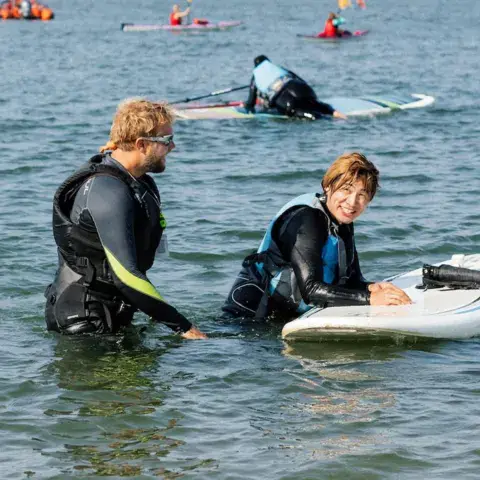 Moniteurs et élèves dans l'eau pendant un cours