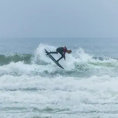 Surfeur en pleine manœuvre sur une vague