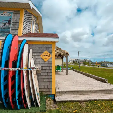 Entrée de la boutique, avec planches de surf, kayaks et SUP en location