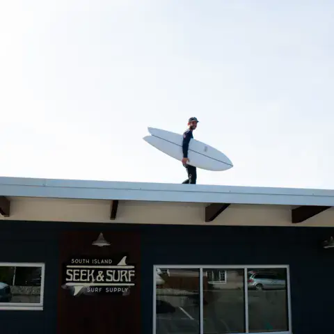 Façade du magasin avec un surfeur sur le toit