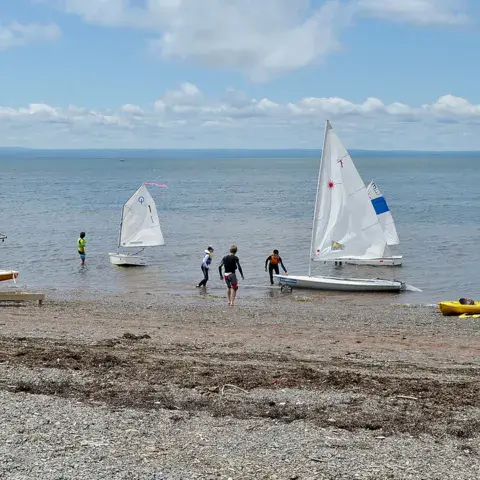 Dériveurs et kayaks sur la plage de la base nautique