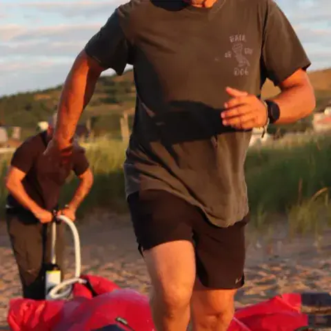 Gonflage d'un kite sur la plage au coucher du soleil