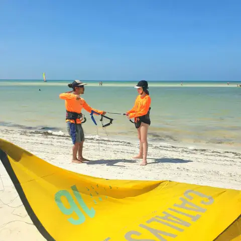 Moniteurs et élève sur la plage avant un cours