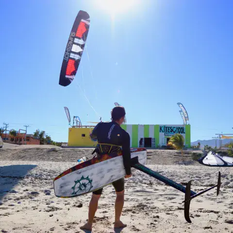 Rider avec un foil devant le centre, un kite dans le ciel
