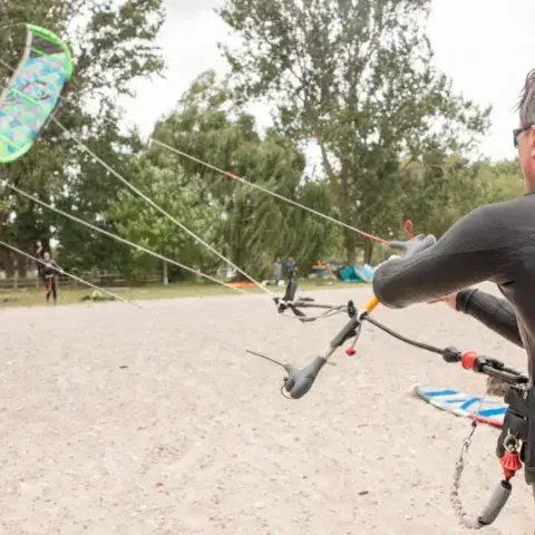 Moniteur et élève préparant un kite sur la plage
