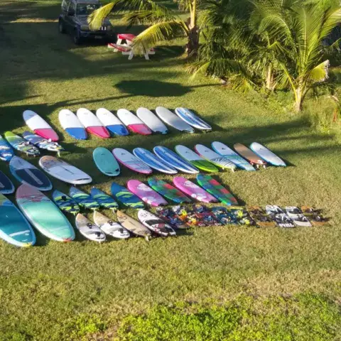 Matériel de windsurf et de surf aligné sur la pelouse de la base
