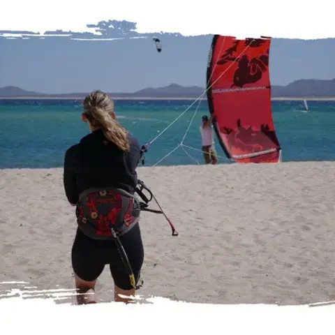 Élève de kite sur la plage pendant une leçon