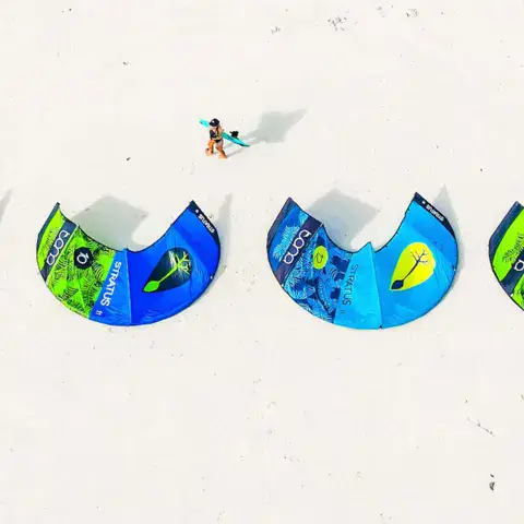 Ailes de kite alignées sur le sable