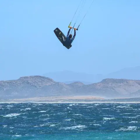Saut de kitesurf devant les montagnes