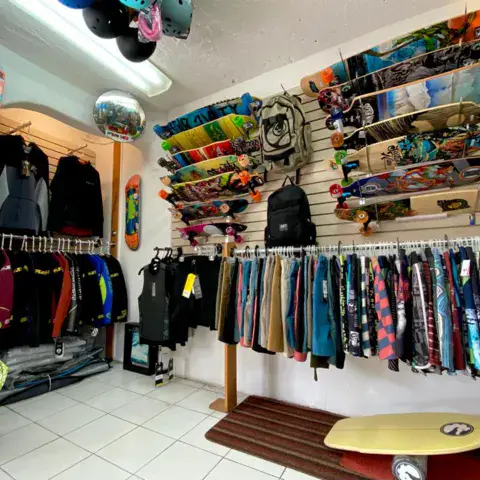 Intérieur du magasin : vêtements, combinaisons et planches
