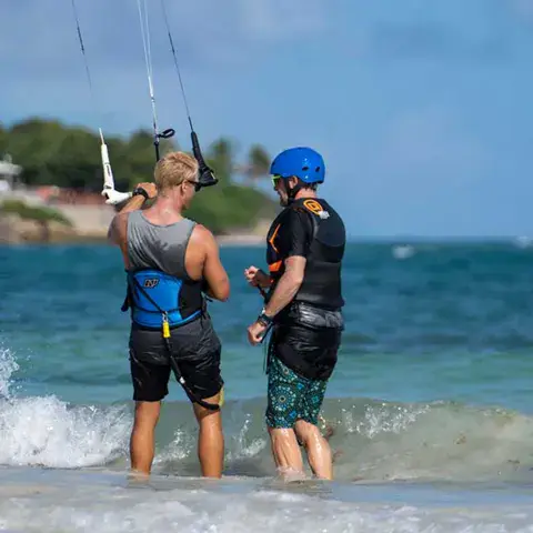 Moniteur et élève dans l'eau pendant une leçon de kitesurf