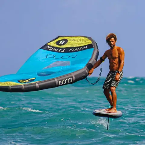 Rider en wing foil tenant son aile