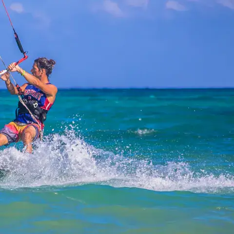 Kitesurfeuse sur une eau turquoise