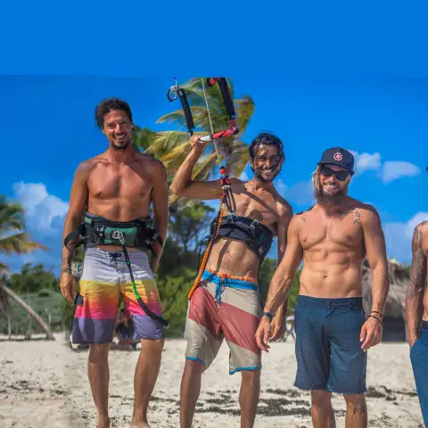 Quatre kiteurs posent sur la plage