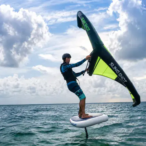 Wing foil en mer sous un ciel nuageux