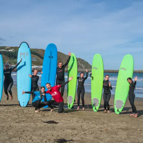 Groupe de surfeurs avec leurs planches de départ sur la plage