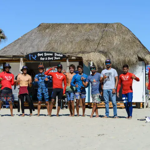 Équipe de l'école devant la palapa et les planches