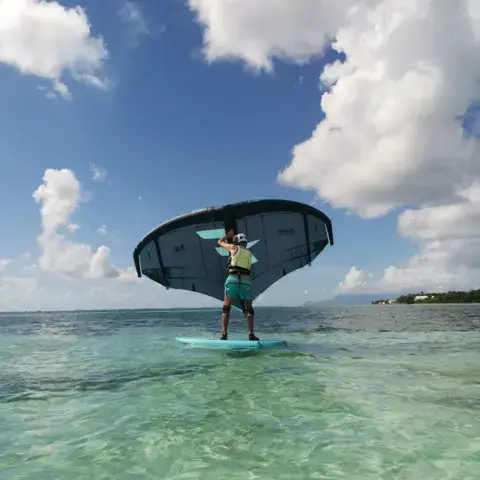 Élève en wingfoil dans le lagon