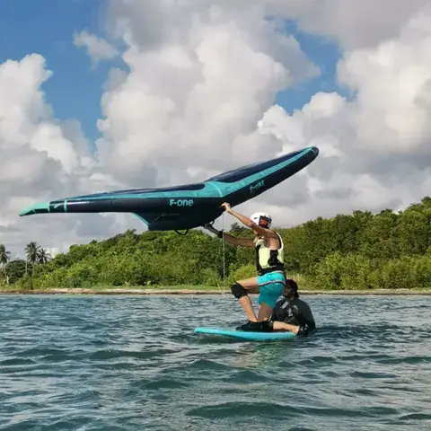 Cours de wingfoil dans l'eau peu profonde du lagon