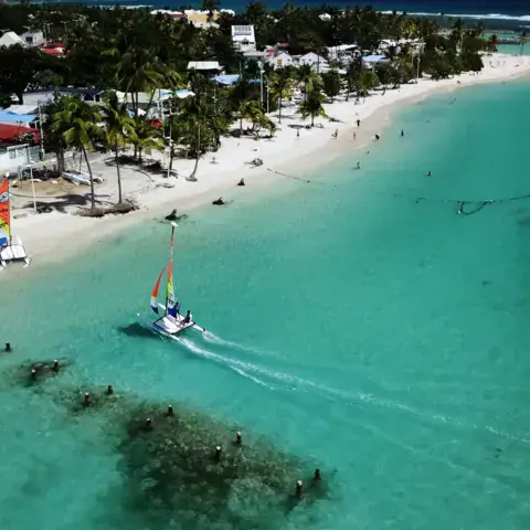 La plage de Sainte-Anne et un dériveur sur le lagon, vue aérienne