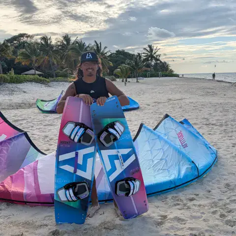 Planches et ailes étalées sur une plage de sable