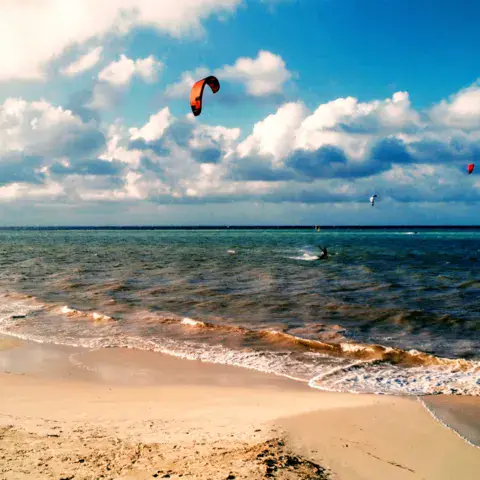 Un kite dans le ciel au-dessus d'une plage et d'une mer turquoise
