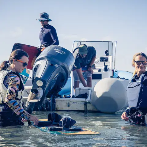 Élèves et moniteurs autour du bateau d'assistance