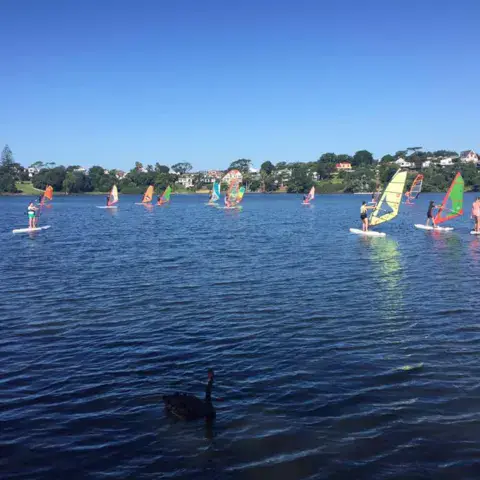 Groupe de windsurfeurs et de planches à voile sur le lac