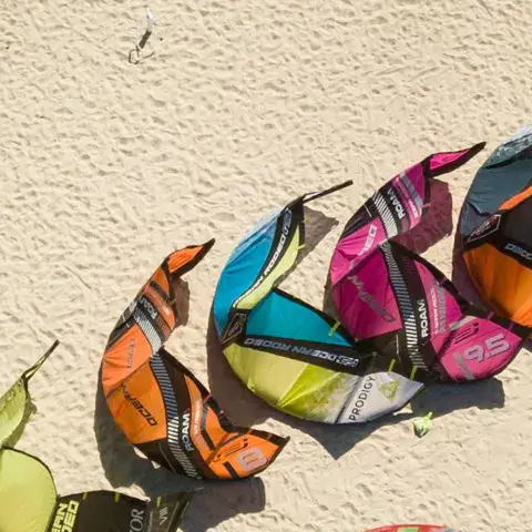 Kites alignés sur le sable