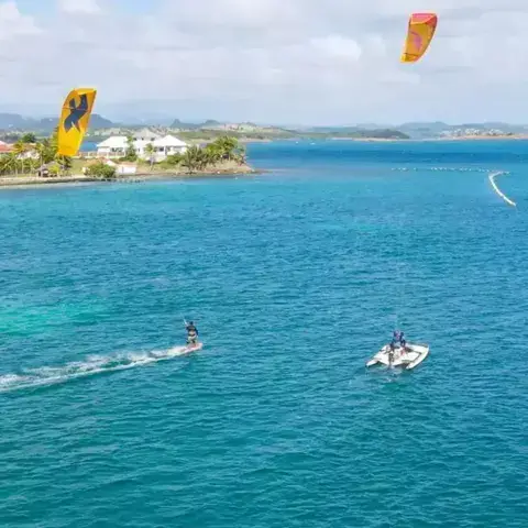 Kitesurfeur et bateau d'assistance dans la baie