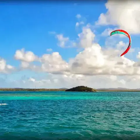 Kitesurfeur sur l'eau turquoise, entre deux îlets
