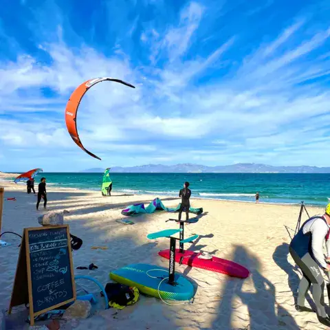Plage avec du matériel de kite et un kite dans le ciel