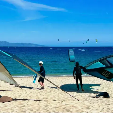 Aile de wing et riders sur la plage