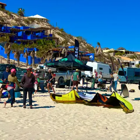 Groupe de kiters et matériel de l'école sur la plage