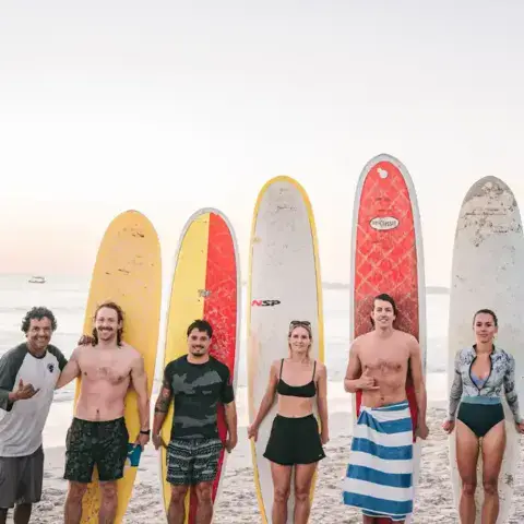 Groupe de surfeurs avec leurs planches sur la plage
