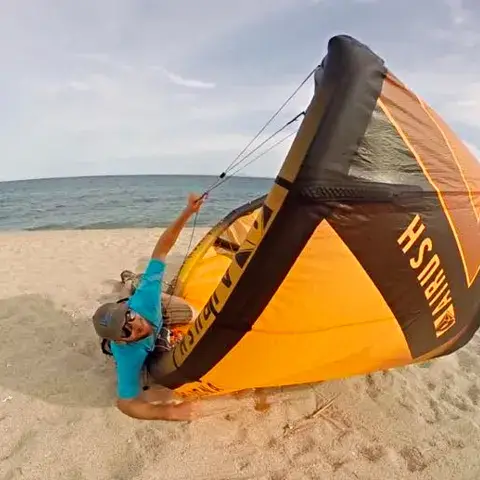 Moniteur qui prépare un kite sur la plage