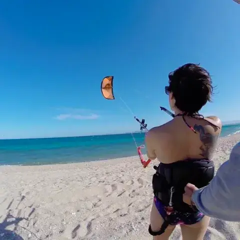 Élève avec un kite dans le ciel sur la plage