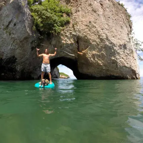 Deux personnes en stand up paddle devant l'arche rocheuse des Arcos de Mismaloya
