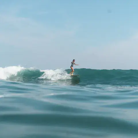 Un surfeur debout sur une vague