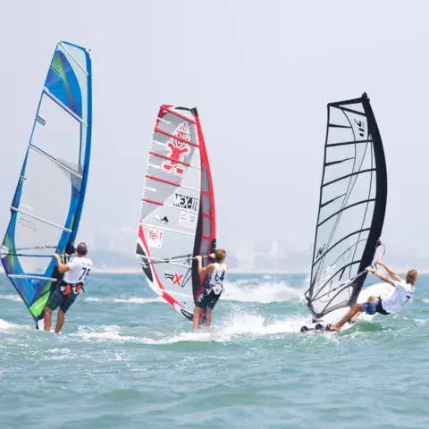 Trois windsurfeurs en navigation