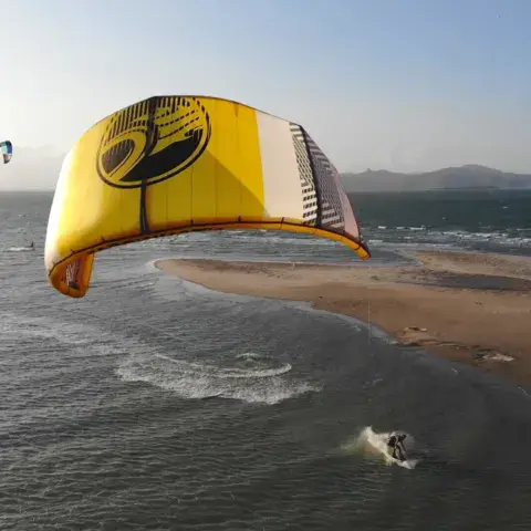 Un kite jaune en vol au-dessus de la lagune