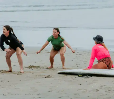 Exercice au sol sur la plage avec une coach