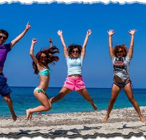 Membres du club qui sautent ensemble sur la plage