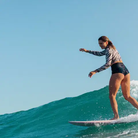 Surfeuse debout sur une vague