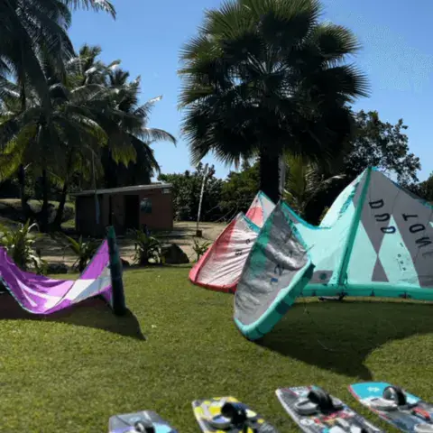 Kites et planches alignés sur la pelouse de la base
