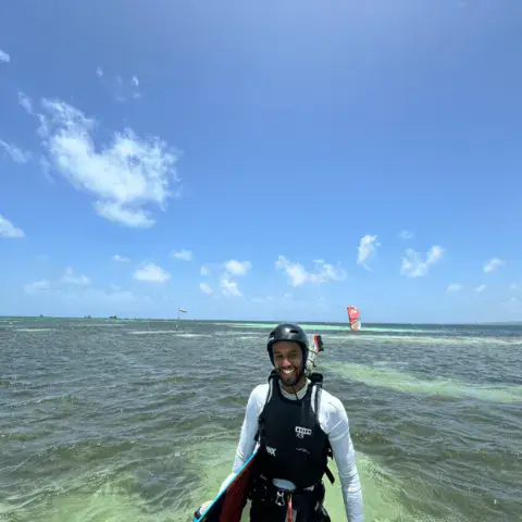 Rider sortant de l'eau avec sa planche en eau peu profonde
