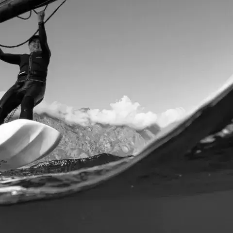 Wingfoileur sous une vague, vue en noir et blanc