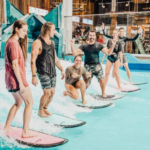 Groupe de surfeurs alignés sur la vague intérieure