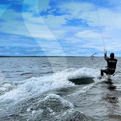 Kitesurfeur en navigation sur l'eau peu profonde
