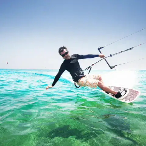 Kitesurfeur en navigation sur une eau turquoise